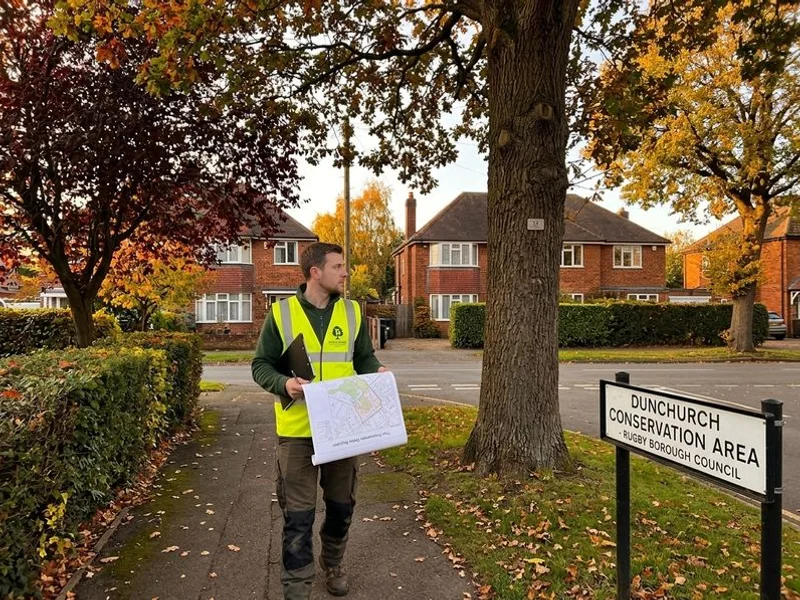 Branchard arborist walking through Dunchurch conservation area with TPO register notes